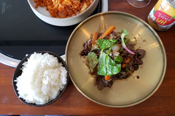 Bulgogi beef with greens beside a bowl of rice