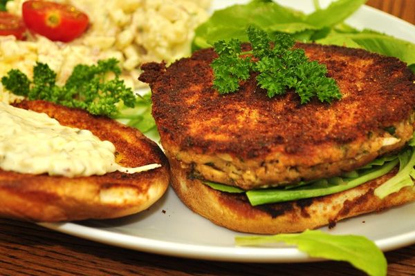 Salmon patty on a bun with salad