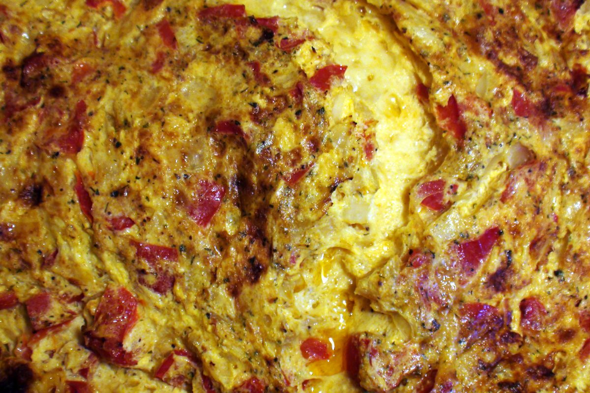Squares of baked egg with vegetables on a board